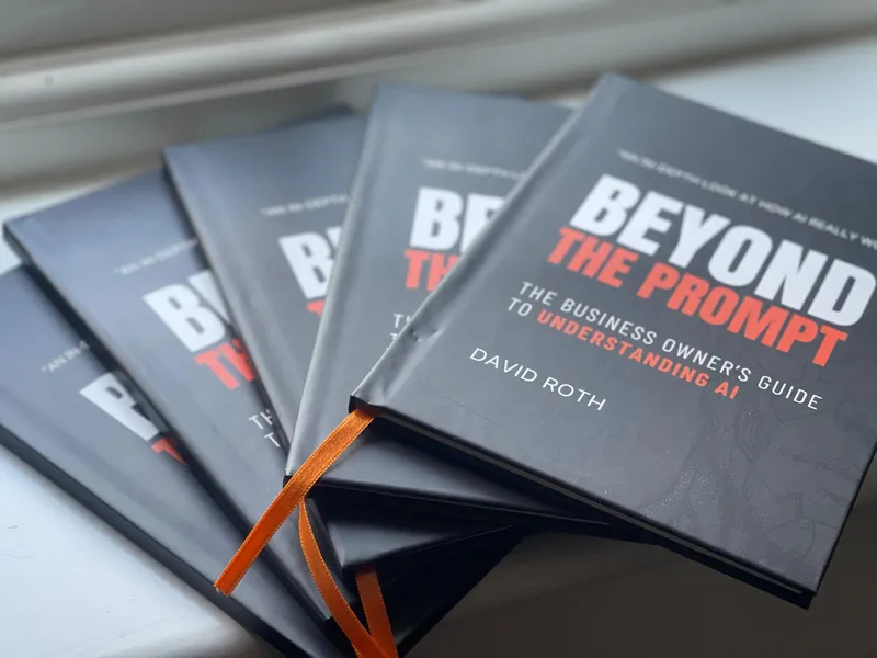 Stacked hardback copies of Beyond the Prompt, David Roth's guide to understanding AI for business owners